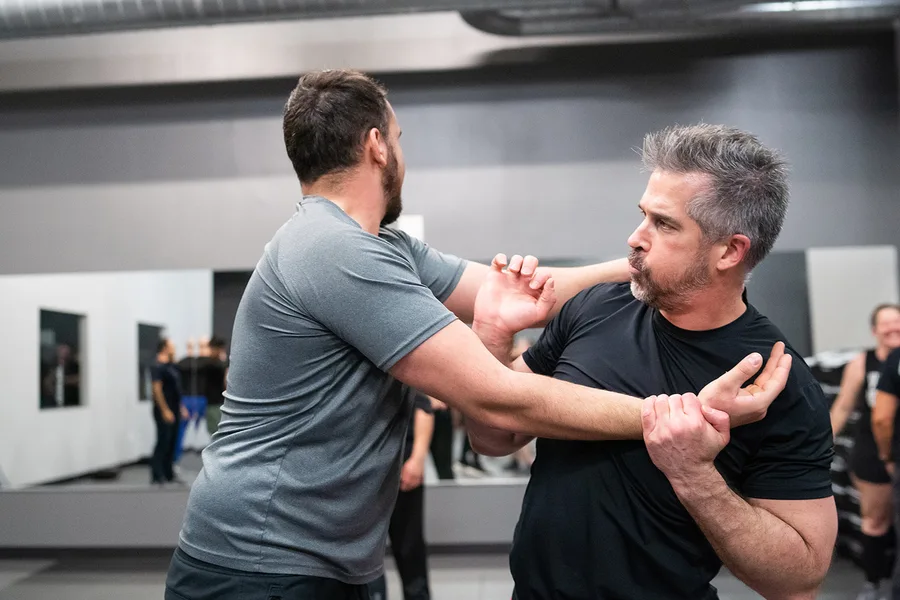 Two adults drilling a real self-defense technique at Colorado Krav Maga
