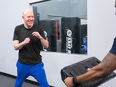 Adult student training Krav Maga strikes on pads with a partner at Colorado Krav Maga